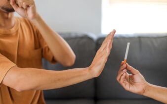 Ex-fumeur qui refuse une cigarette lors d’un moment social, confiant dans son sevrage
